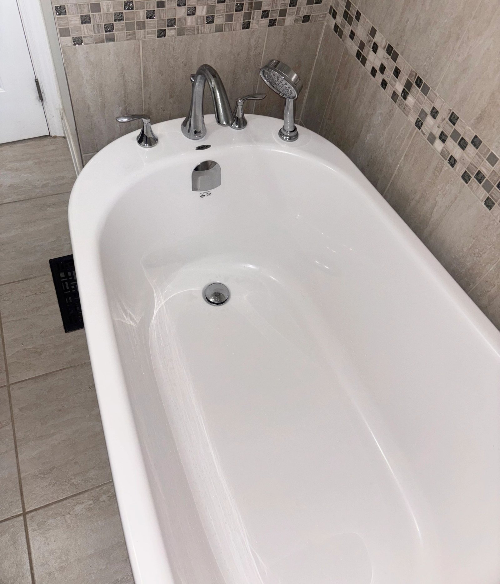 Freestanding tub with mosaic tile surround